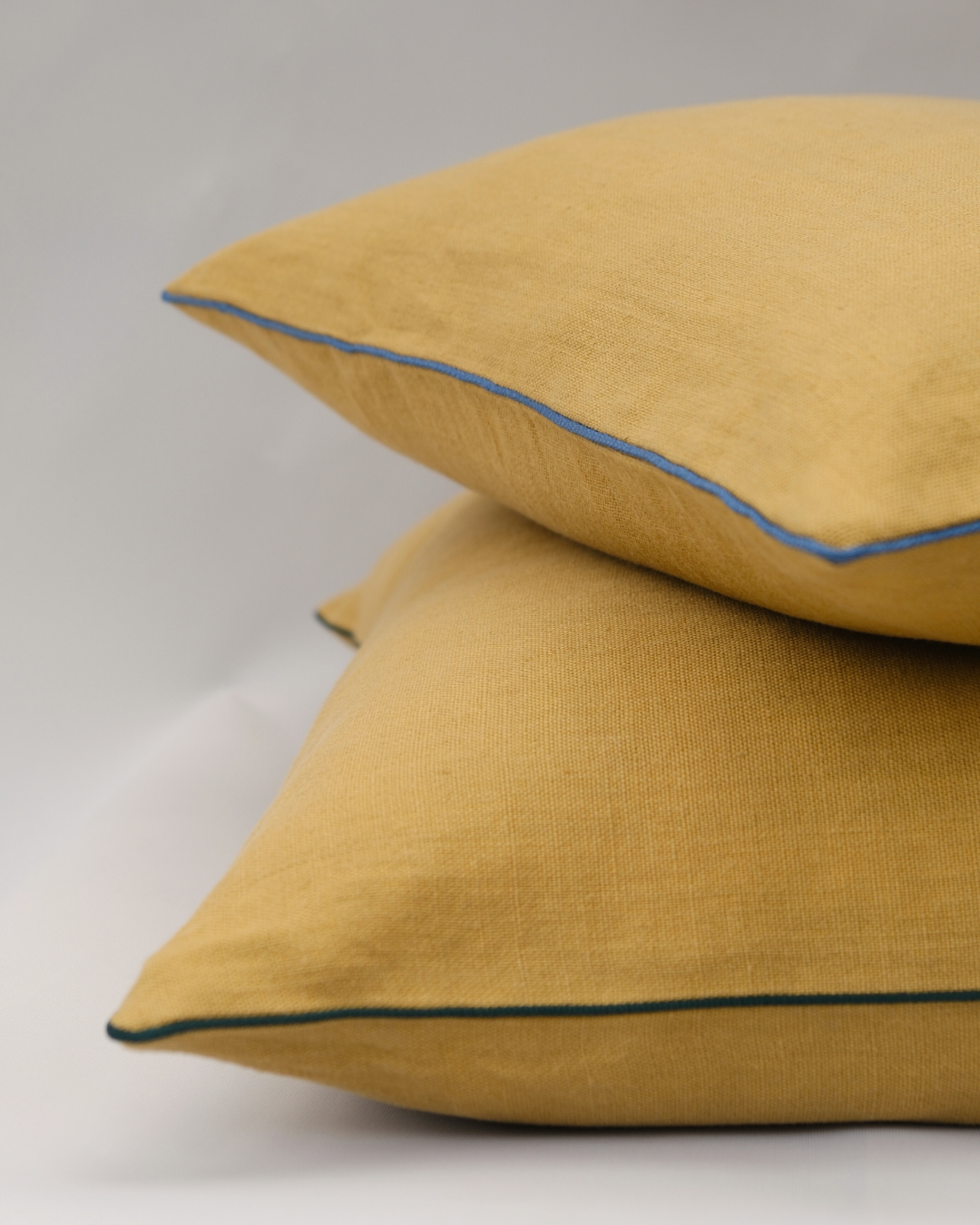 COJIN LINO MOSTAZA CON VIVO AZUL PIEDRA / 50 X 50 CM