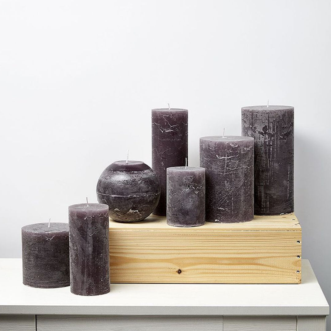 Velas cilíndricas color Aubergine en diferentes tamaños, ideales para decorar el hogar.