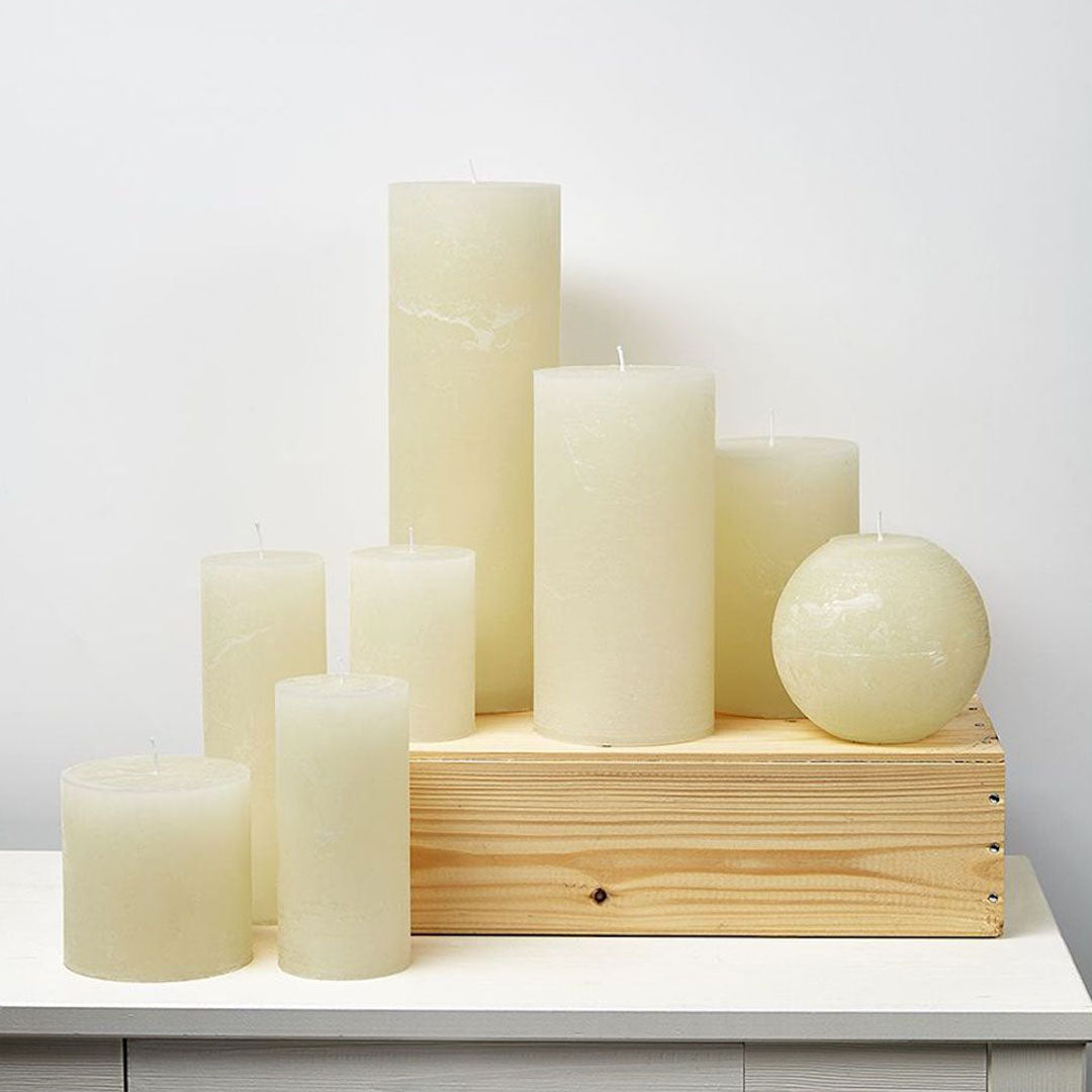 Variedad de velas cilíndricas color Off White en diferentes tamaños, ideales para decoración de eventos y el hogar.