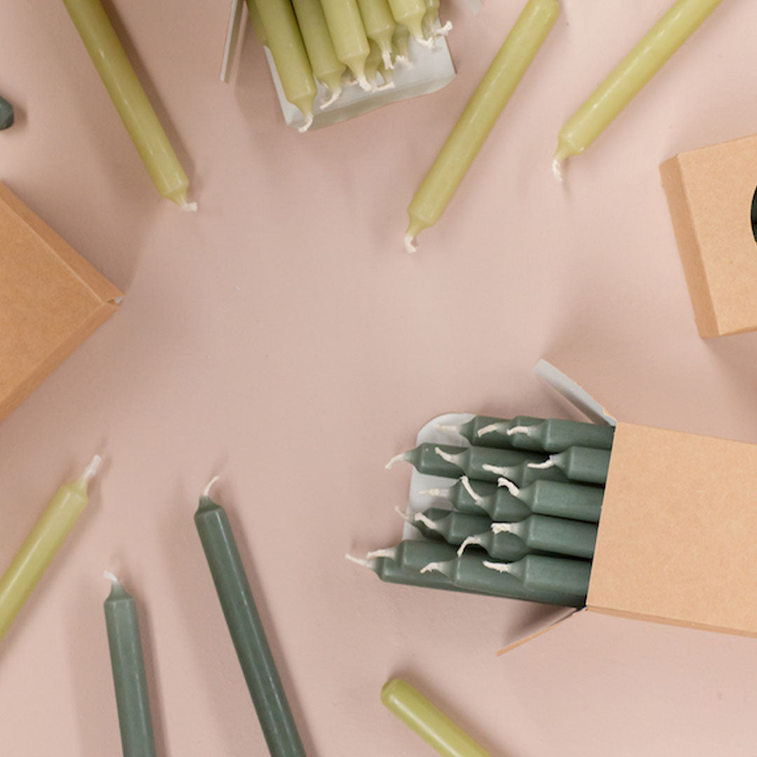 Velas cónicas color Eucaliptus decorando un ambiente acogedor.