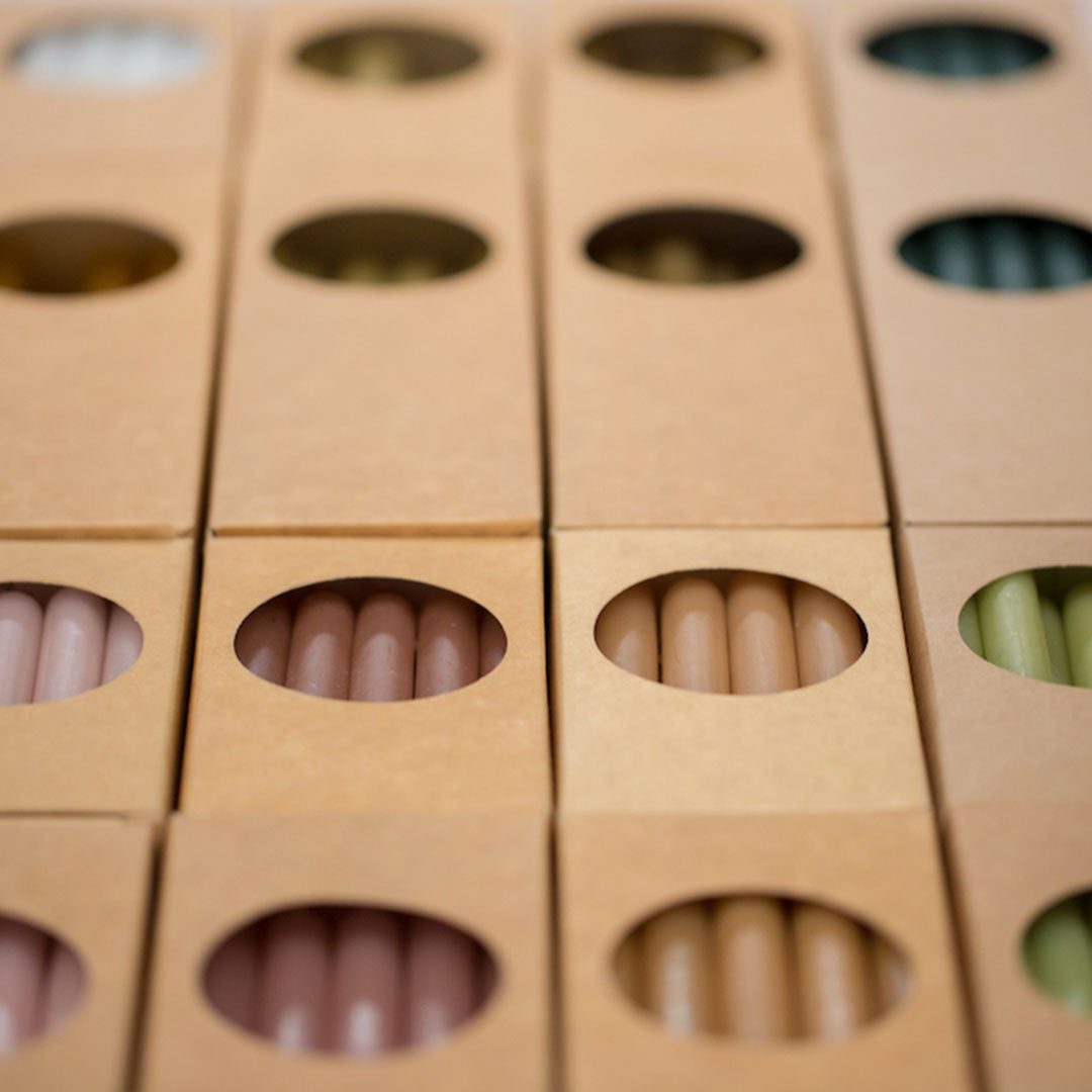 Velas cónicas color Linnen en un centro de mesa, añadiendo calidez a la decoración.