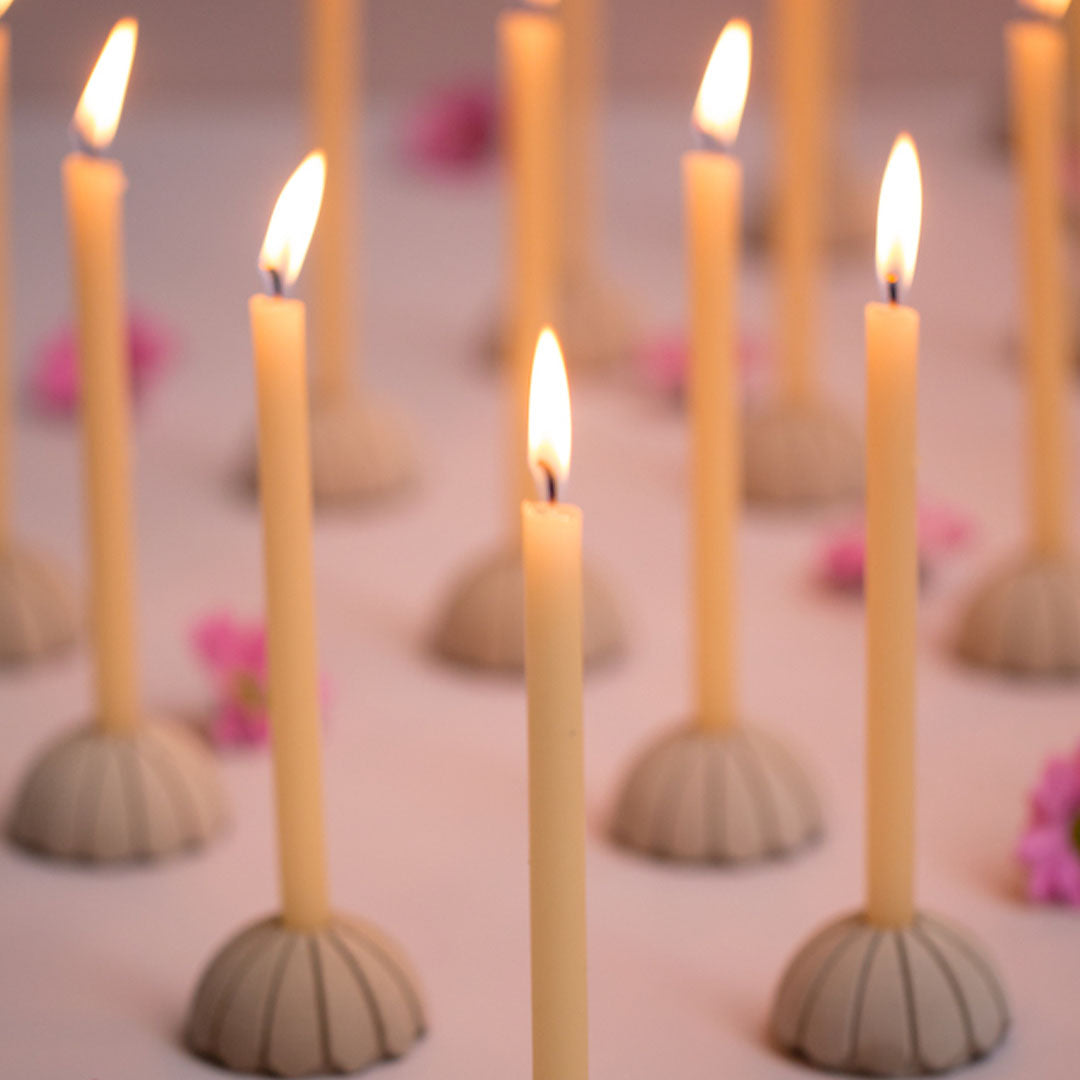 Velas cónicas color Pale Banana decorando un ambiente rústico y acogedor.