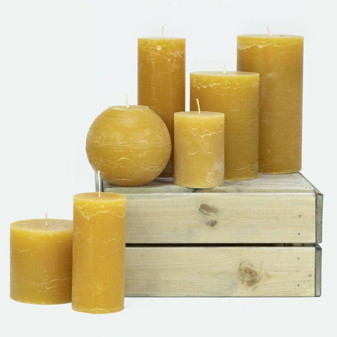 Velas cilíndricas color Natural en diferentes tamaños, ideales para decorar cualquier espacio.